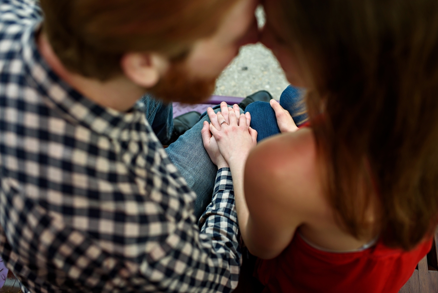 Two people in love hold hands and kiss outside of 30th street station.